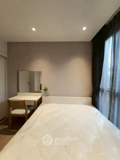 Cozy bedroom with natural light and elegant decor, featuring a comfortable bed and a stylish vanity desk.