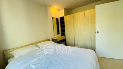 Cozy bedroom with modern wardrobe and soft lighting, perfect for relaxation.