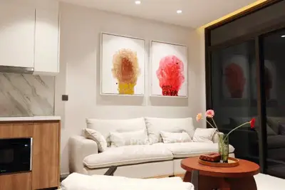 Modern living room with stylish decor and cozy seating area, featuring contemporary artwork and elegant lighting.