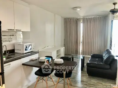 Modern open-layout kitchen and living room with sleek furniture and natural light.