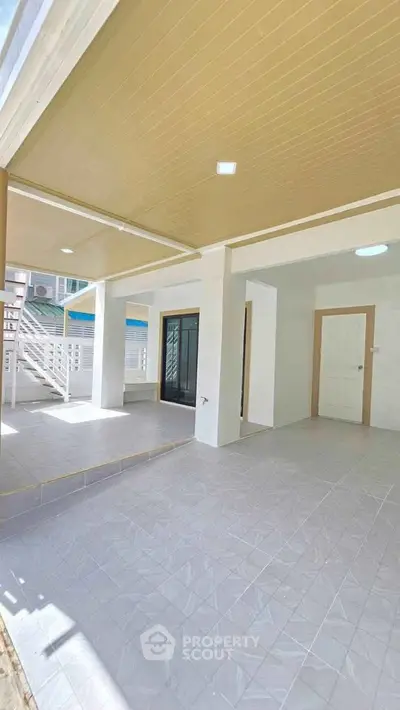 Spacious covered patio with modern design and ample natural light, perfect for outdoor relaxation.