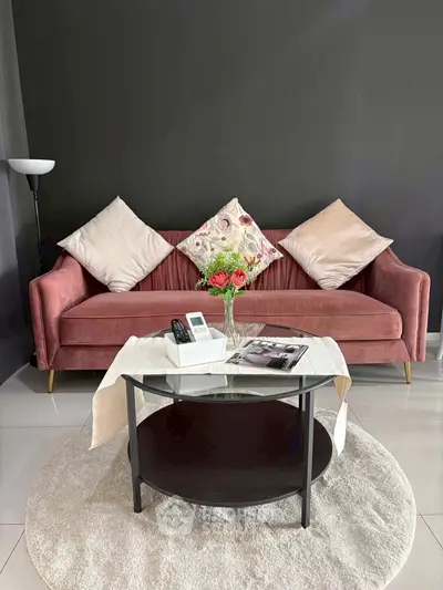 Stylish living room with pink velvet sofa, elegant decor, and modern glass coffee table.