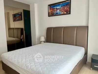 Modern bedroom with large bed and mirrored wardrobe, perfect for comfort and style.
