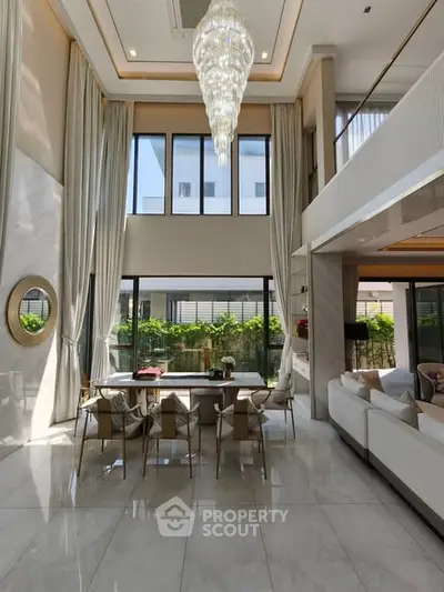 Luxurious double-height living room with elegant chandelier and modern decor