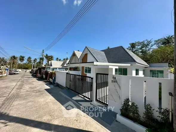 Charming modern house with sleek design and gated entrance in a serene neighborhood.