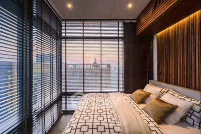 Luxurious bedroom with floor-to-ceiling windows offering stunning city views and elegant decor.
