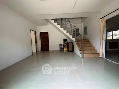 Spacious unfurnished living room with staircase and tiled flooring