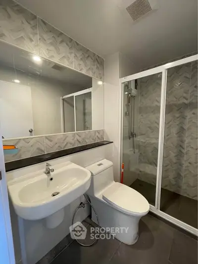 Modern bathroom with sleek design featuring a glass shower enclosure and stylish tile accents.