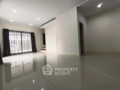Spacious empty living room with glossy floors and large windows