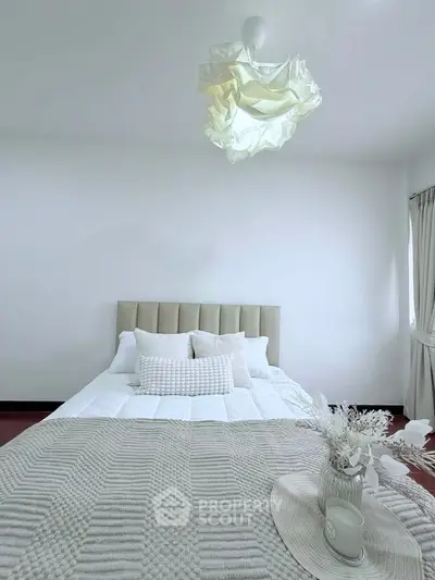 Elegant bedroom with modern decor and cozy bedding in a bright, minimalist style.