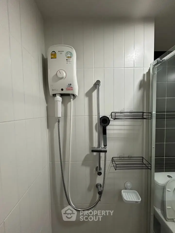 Modern bathroom with sleek shower unit and white tiled walls, perfect for a contemporary home.