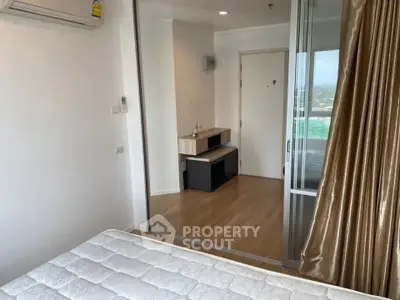 Modern bedroom with mirrored closet and air conditioning in a high-rise apartment.