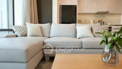 Modern living room with stylish sofa and open kitchen layout, perfect for contemporary urban living.