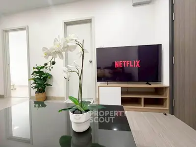 Modern living room with sleek TV setup and elegant decor, perfect for relaxation and entertainment.