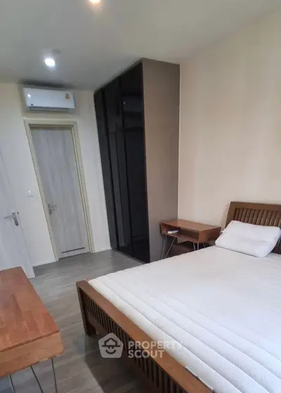 Modern bedroom with wooden furniture and sleek design in a cozy apartment.