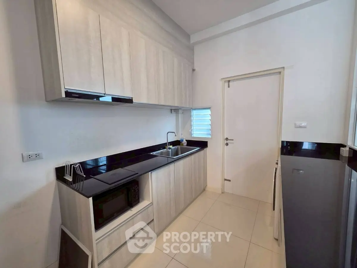 Modern kitchen with sleek cabinetry and black countertops