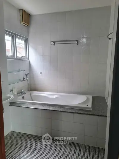 Spacious bathroom with modern bathtub and tiled walls