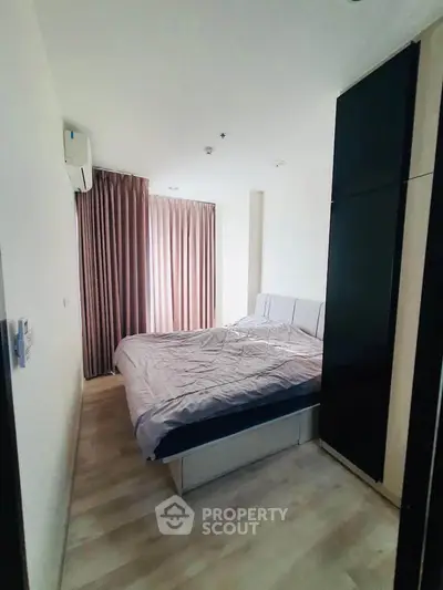 Cozy bedroom with natural light and modern furnishings in a stylish apartment.