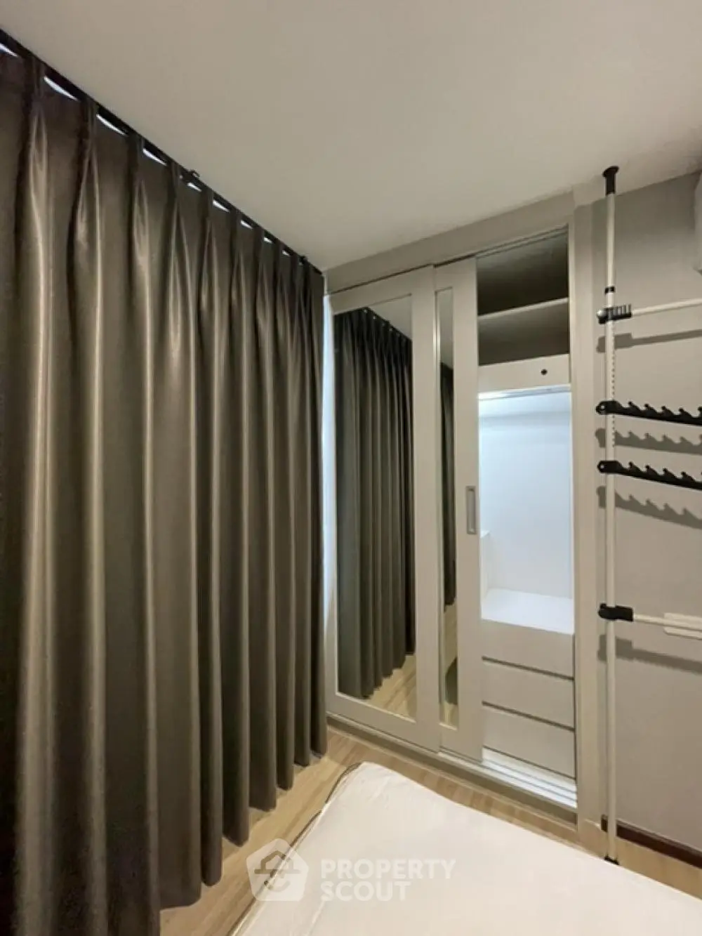 Modern bedroom with mirrored wardrobe and elegant curtains