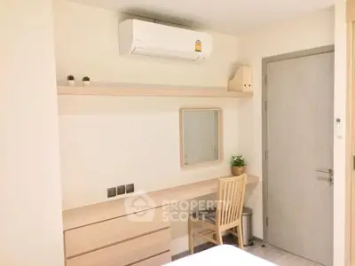 Modern bedroom with minimalist desk and air conditioning unit.