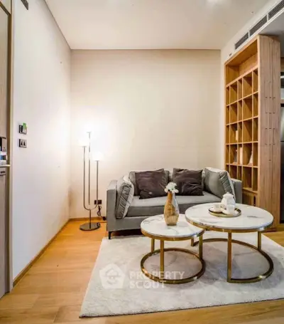 Stylish living room with modern sofa, elegant lighting, and chic coffee tables on a plush rug.