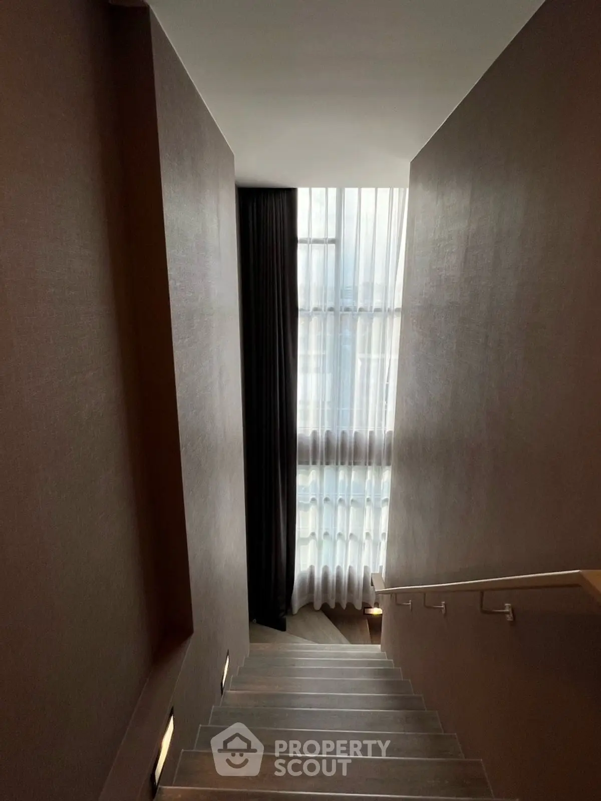 Elegant staircase with modern design and large window for natural light