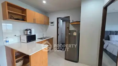Modern kitchen with wooden cabinets and stainless steel appliances in a cozy apartment.
