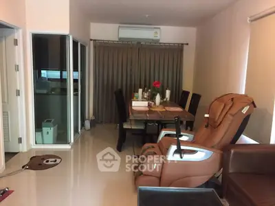Spacious dining area with massage chair and modern decor in cozy apartment.