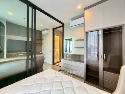 Modern bedroom with sleek design and city view, featuring built-in storage and air conditioning.