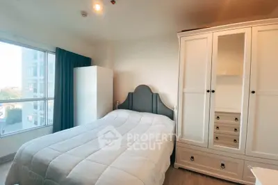 Cozy bedroom with large window and stylish wardrobe in modern apartment.