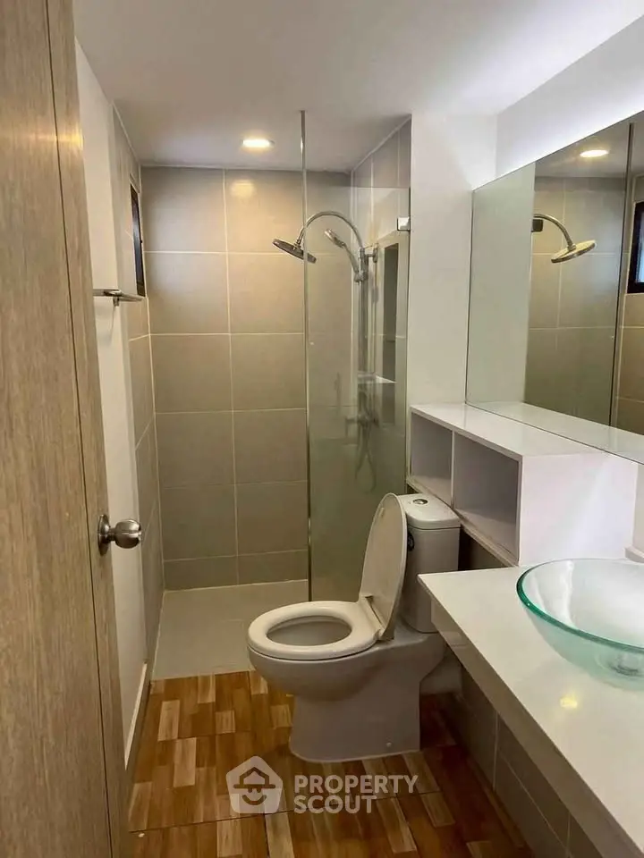 Modern bathroom with glass shower and stylish sink in a compact layout.