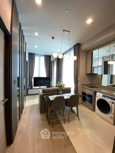 Modern open-plan living and dining area with stylish decor and in-unit washer for convenience.