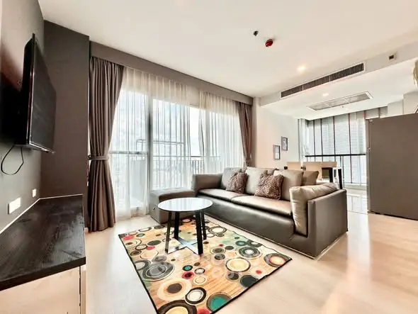 Modern living room with stylish decor and large windows in a luxury apartment.