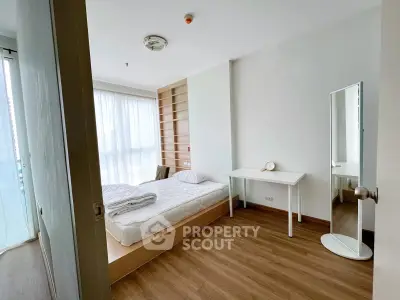 Bright minimalist bedroom with wooden flooring and large window