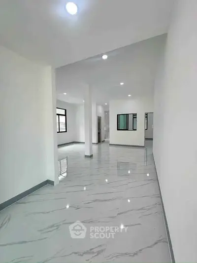 Spacious modern interior with glossy marble flooring and ample natural light.