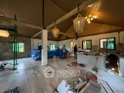Spacious under-construction living room with high ceilings and modern lighting fixtures