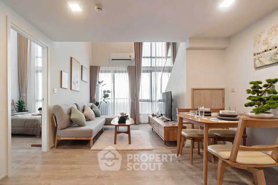 Modern living room with stylish furniture and open layout, featuring natural light and elegant decor.
