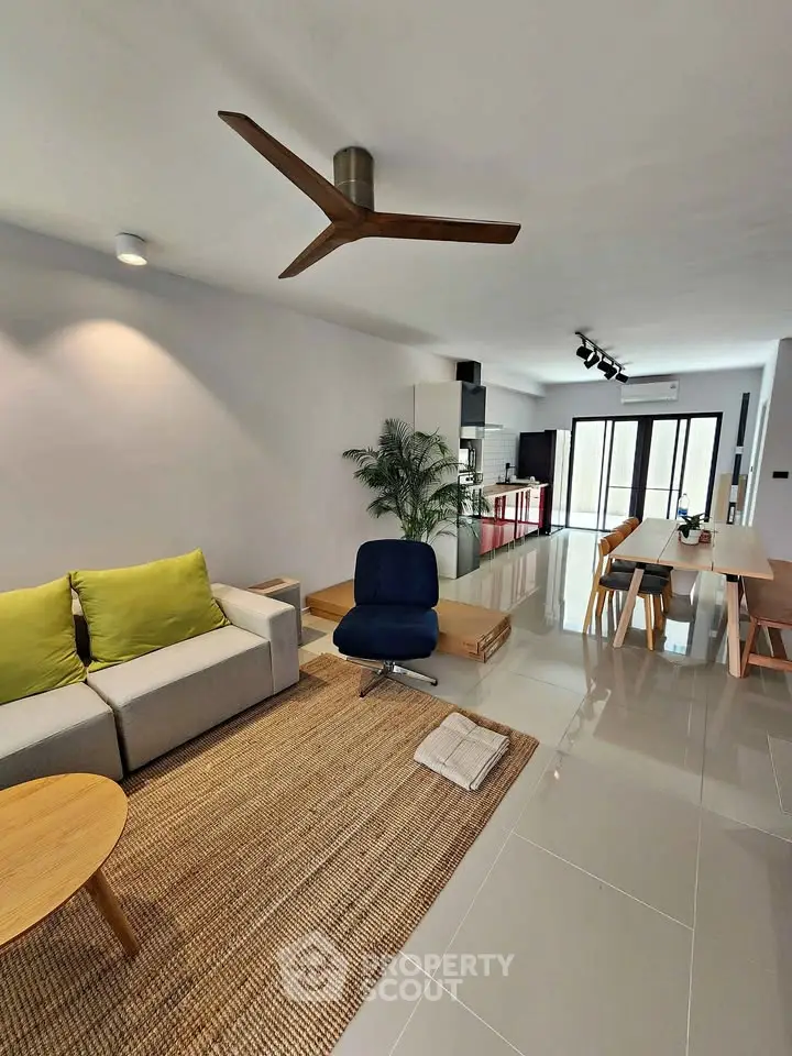 Modern living room with stylish furniture and open layout, featuring a cozy sofa and dining area.
