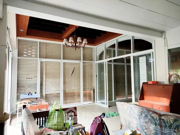 Spacious sunlit room with large windows and modern decor