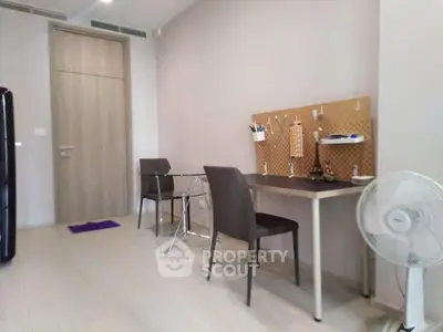 Modern study area with sleek desk and chairs in a minimalist apartment.