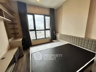 Modern bedroom with city view, featuring sleek furniture and large windows.