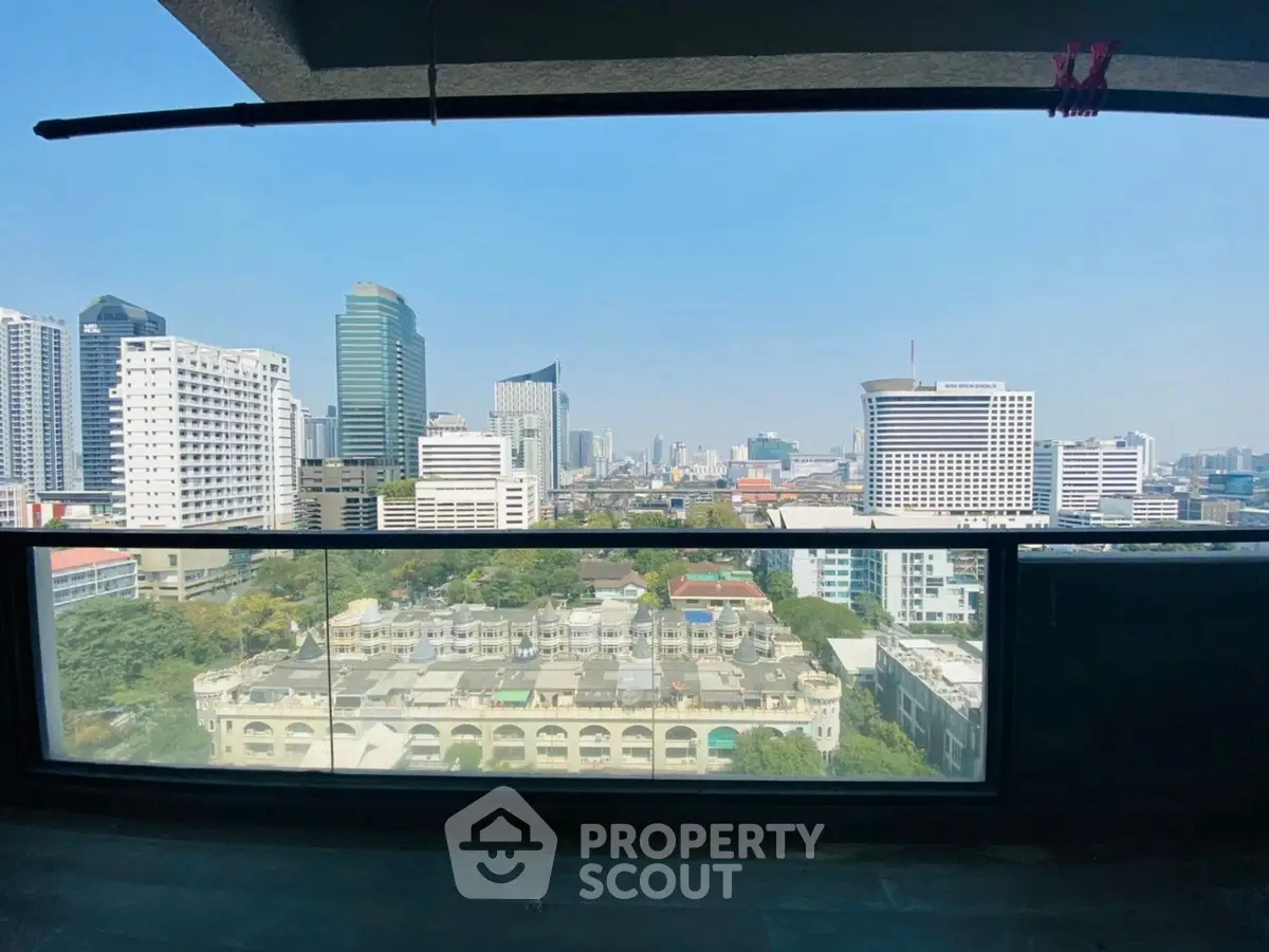 Stunning cityscape view from high-rise balcony with clear blue sky.