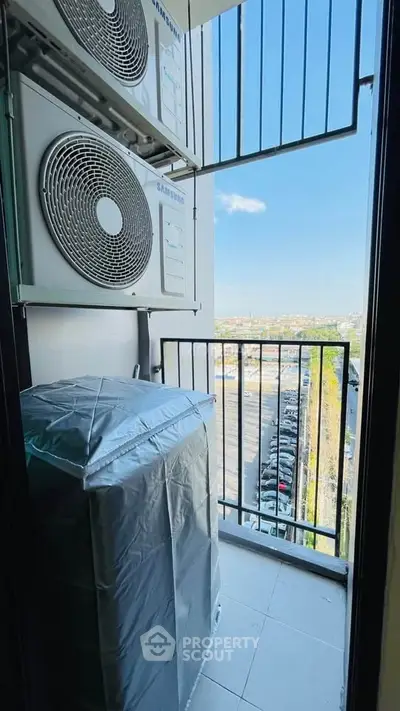 Compact balcony with air conditioning units and city view, ideal for urban living.