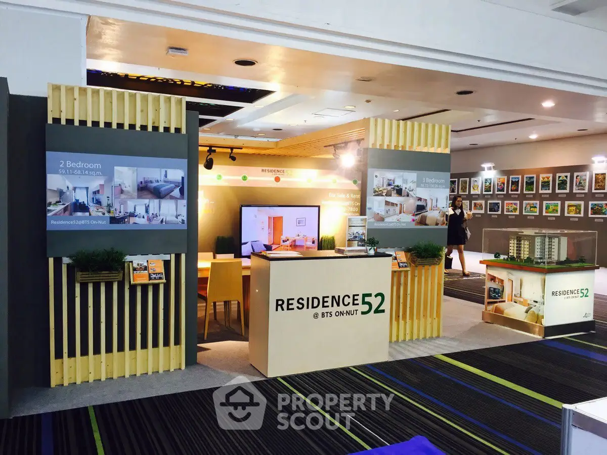 Modern real estate exhibition booth showcasing Residence 52 with stylish interior design and property models.
