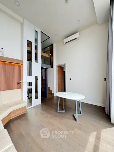 Modern living room with high ceiling and stylish decor in a contemporary apartment.