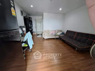 Spacious living room with modern furniture and wooden flooring in a cozy apartment.