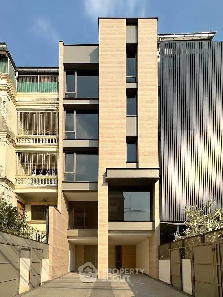 Modern multi-story building with sleek facade and large windows, ideal for urban living.