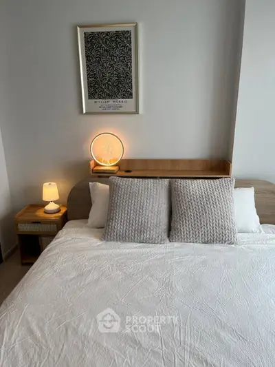 Cozy bedroom with modern decor and soft lighting, featuring a stylish headboard and elegant artwork.