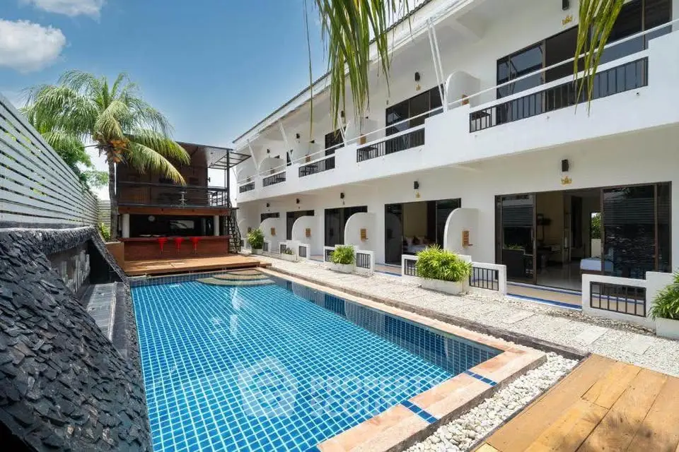 Luxurious modern building with stunning pool and palm trees, perfect for relaxation and leisure.