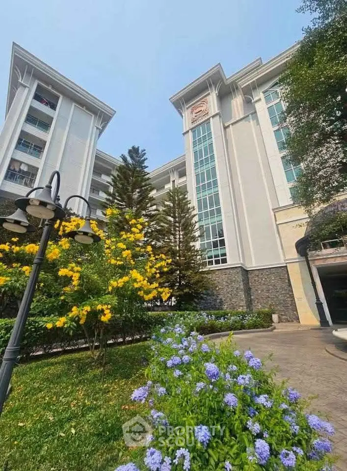 Elegant residential building with lush garden and vibrant flowers